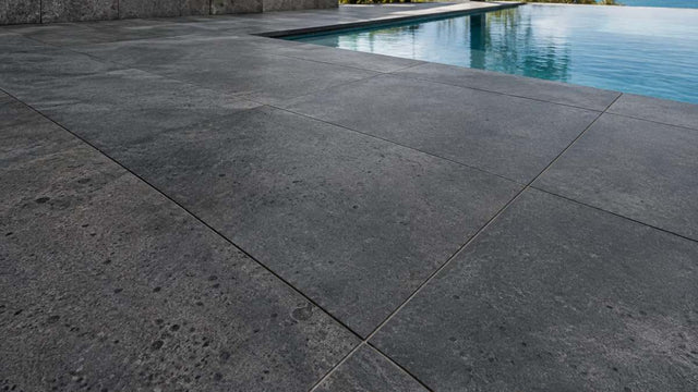 Honed dark grey basalt pavers around a swimming pool